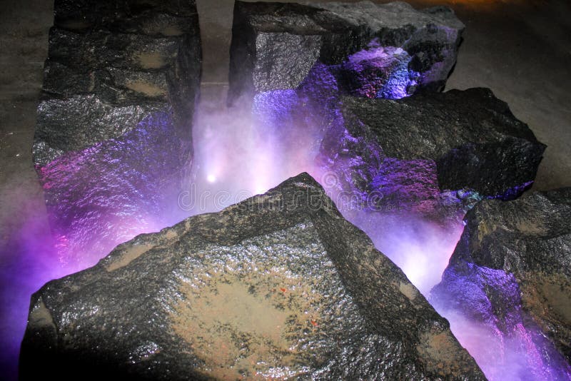 Top view of purple mist coming out of rock mist fountain in park