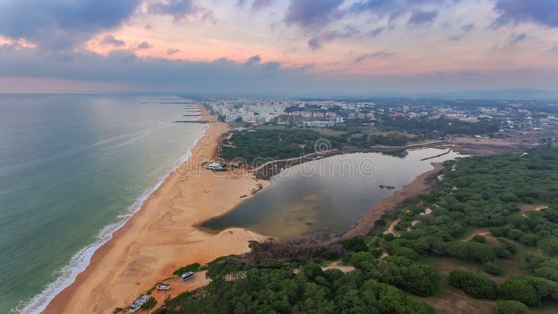 Top view Quarteira beach with tourists on the sea.