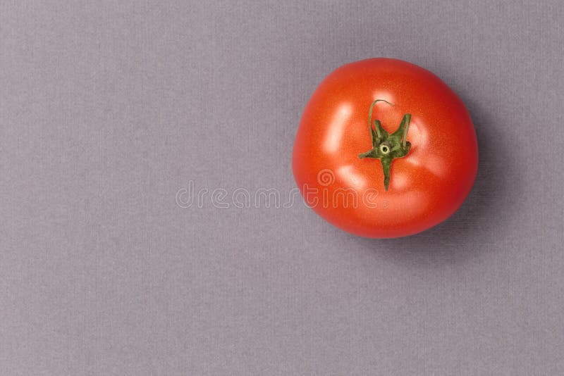 Top view of red juicy tomato on a grey background