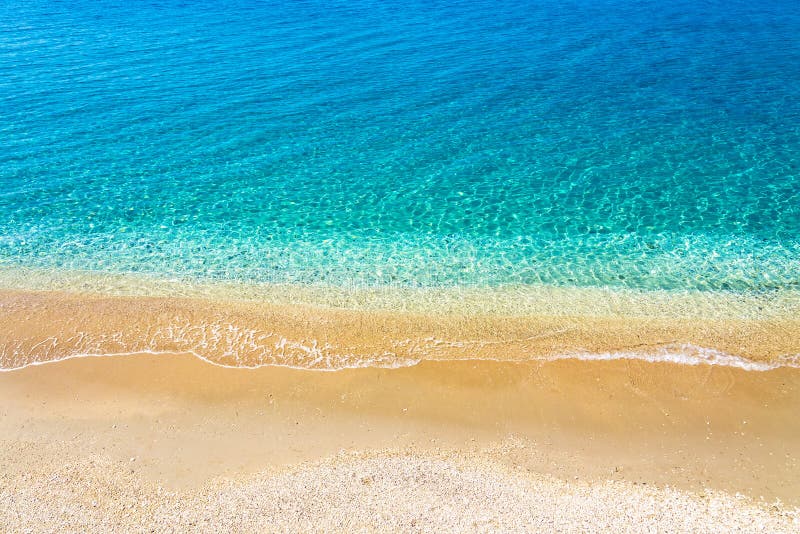 Top view of sandy beach and turquoise ocean water with small waves, beautiful summer sea background