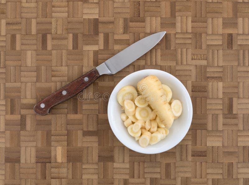 Bowl of parsnip slices on a wood cutting board royalty free stock photos