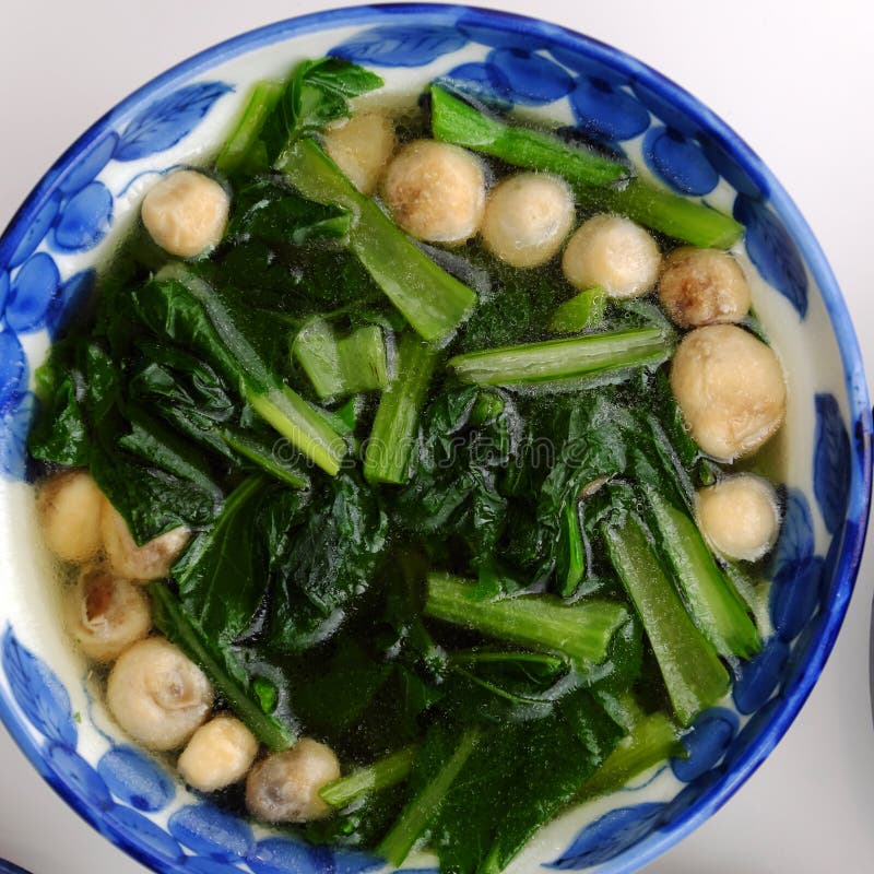 Top view spinach and straw mushroom soup bowl for vegan meal royalty free stock photo
