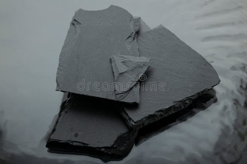 Top view of stack of flat black natural stones on gray surface royalty free stock images