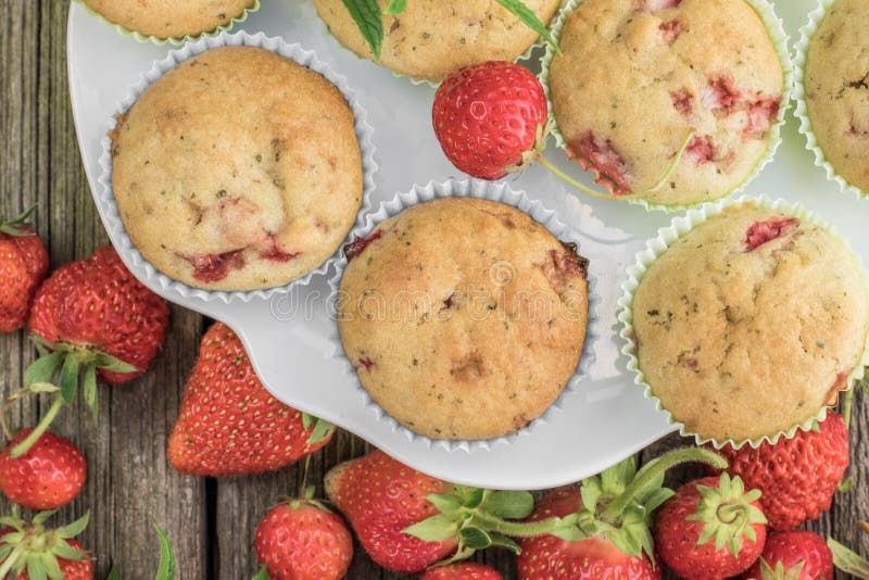 Top View on a Strawberry and Mint Muffins on White Plate on a Old Wooden Board