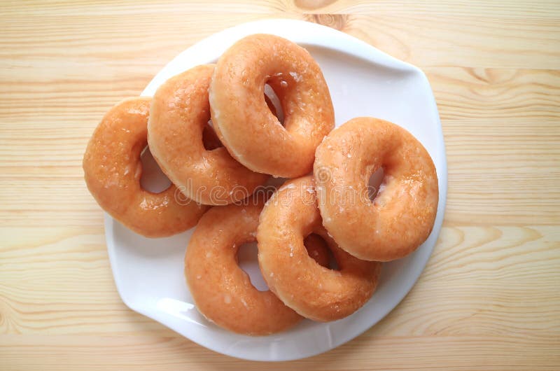 Top View of Sugar-glazed Doughnuts Served on White Plate on Wooden Table royalty free stock image Top View of Sugar-glazed Doughnuts Served on White Plate on Wooden Table royalty free stock image