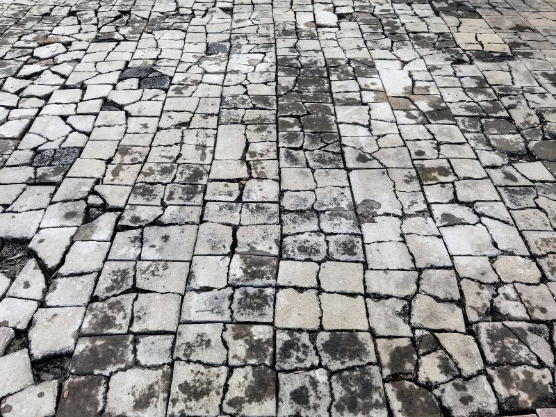 Top view texture of the brick blocks floor in the cracks. The surface of the public outdoor walkway or pavement is broken and royalty free stock photo