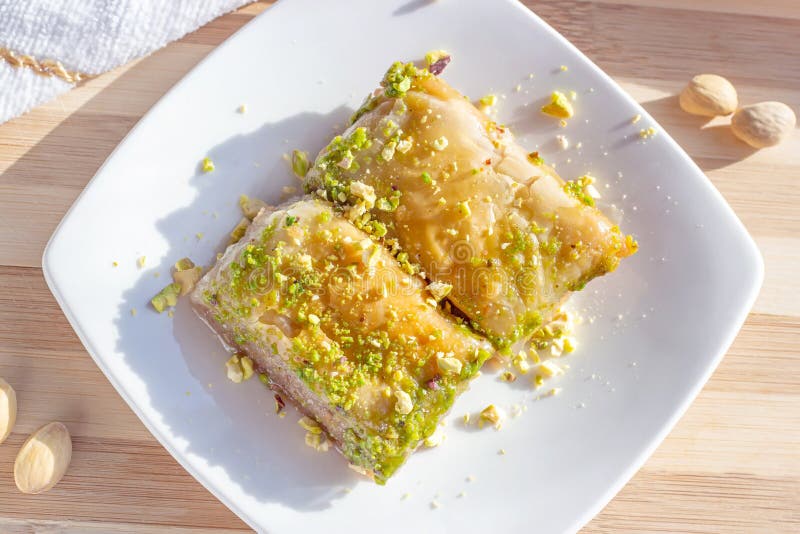 Top view of traditional East Asian sweet baked bahlava or pahlava with nuts and syrup on a white plate stock photography Top view of traditional East Asian sweet baked bahlava or pahlava with nuts and syrup on a white plate stock photography