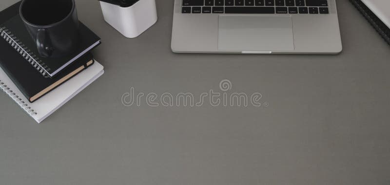 Top view of trendy workplace with laptop computer and office supplies on dark grey table background stock photo