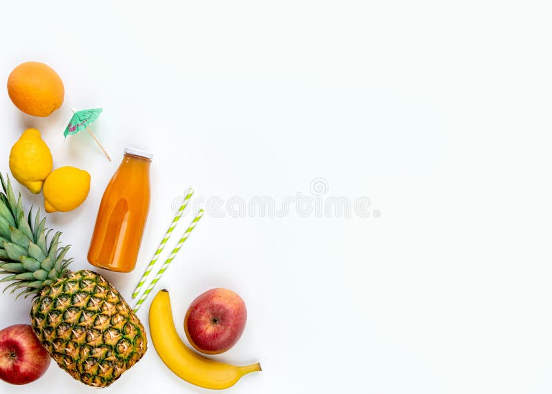 Top view of various fruits, a bottle of freshly squeezed multivitamin juice and cocktail accessories on a white background. Copy stock image Top view of various fruits, a bottle of freshly squeezed multivitamin juice and cocktail accessories on a white background. Copy stock image