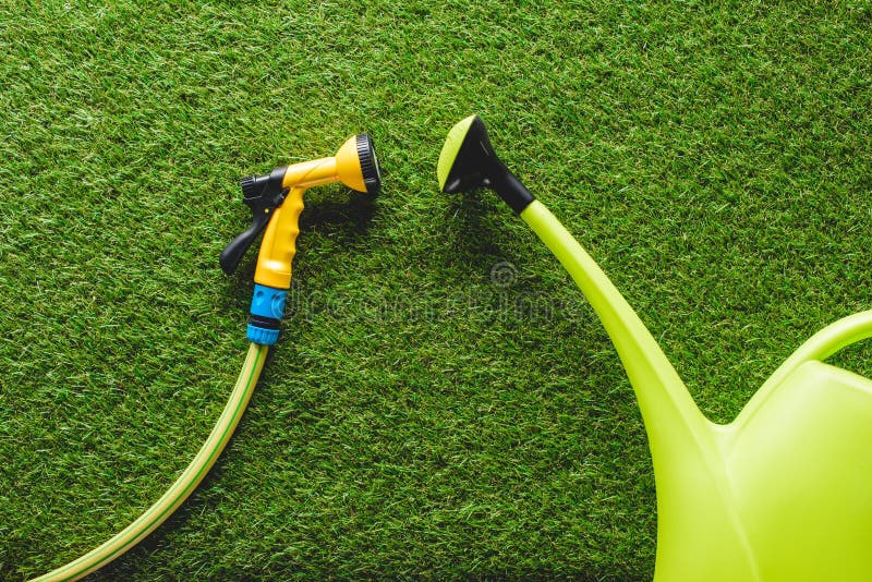 top view of watering can and hosepipe on grass, minimalistic conception stock images top view of watering can and hosepipe on grass, minimalistic conception stock images