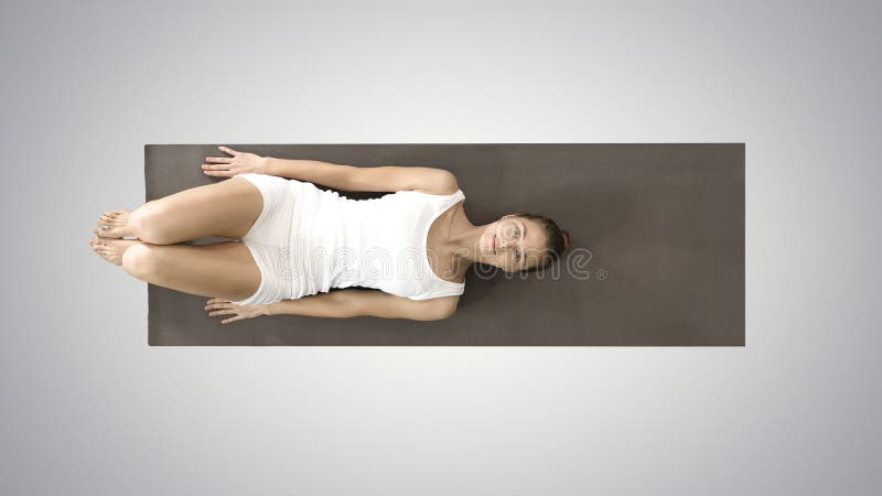 Top view. Woman practicing yoga, standing in salamba sarvangasana exercise, supported Shoulder stand pose on gradient background. Professional shot in 4K resolution. 008. You can use it e. g. in your commercial video, business, presentation, broadcast