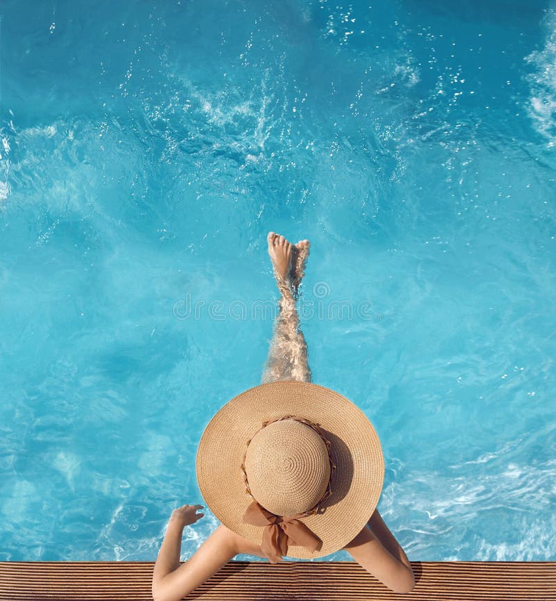 Top view of woman in straw hat relaxing in swimming pool at luxury villa resort. Summer holiday idyllic background. Vacations Con