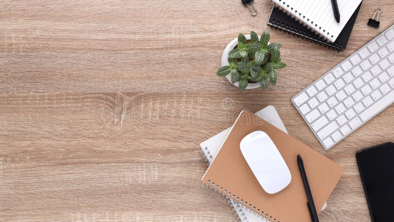 Top view wooden workspace office desk with computer and office supplies. Flat lay work table with blank notebook, keyboard, green stock photography