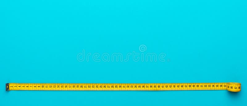 Top view of yellow measuring tape over turquoise blue background with copy space