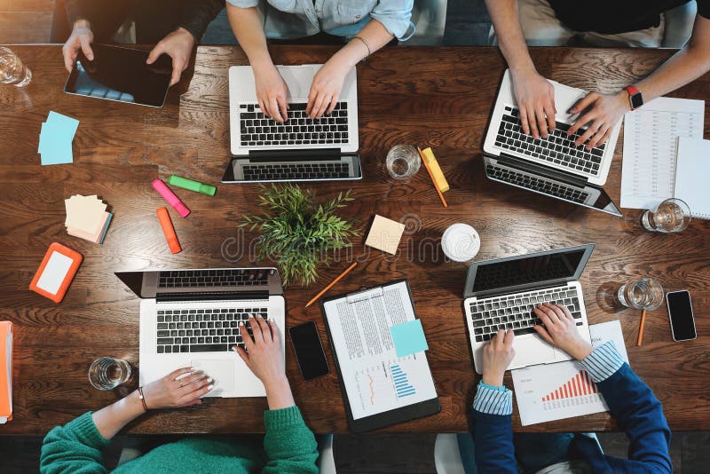Vedere de sus a tinerilor analizatori de afaceri care stau la masă. colaborare în echipă stock photography