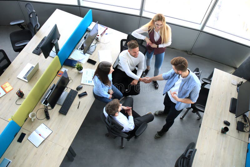 Top view of young business partners shaking hands over deal at office. Focus on hand shake. stock photos Top view of young business partners shaking hands over deal at office. Focus on hand shake. stock photos