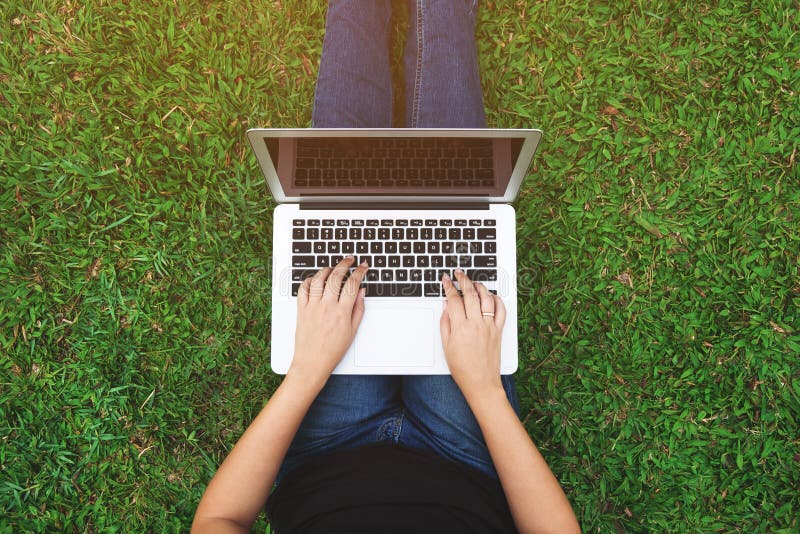 Top view of young woman using laptop on a grass stock photos Top view of young woman using laptop on a grass stock photos