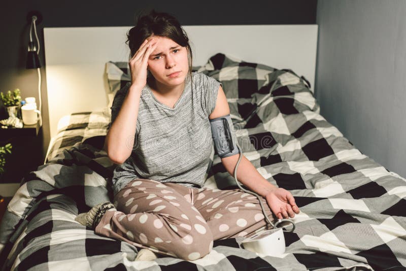The topic of high blood pressure is hypertension disease. 22 year old young Caucasian woman uses an automatic tonometer to check royalty free stock images The topic of high blood pressure is hypertension disease. 22 year old young Caucasian woman uses an automatic tonometer to check royalty free stock images