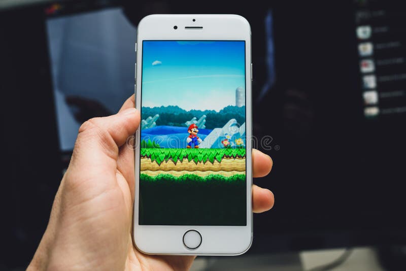 KAUNAS, LITHUANIA - December 19, 2016 : Apple iPhone6s held in one hand showing its screen with Super Mario Run game. KAUNAS, LITHUANIA - December 19, 2016 : Apple iPhone6s held in one hand showing its screen with Super Mario Run game