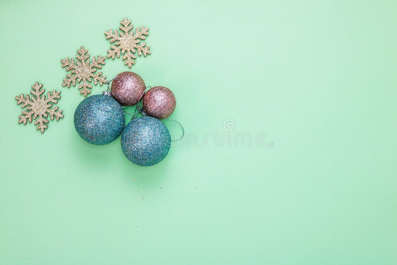 Toppvy av glittery snowflakes färgstarka julbullar som isolerats på den gröna bakgrunden royaltyfri bild