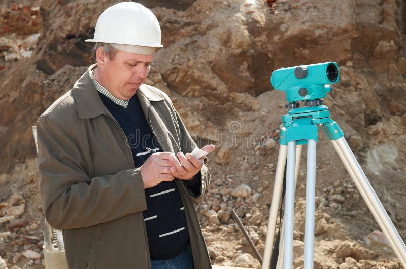 Worker surveyor measuring distances, elevations and directions on construction site by theodolite level transit equipment. Worker surveyor measuring distances, elevations and directions on construction site by theodolite level transit equipment