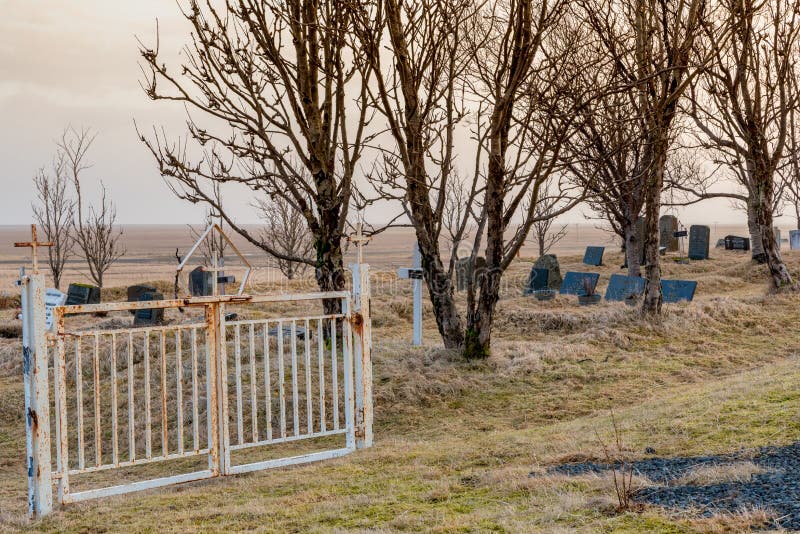 Tor in den Kalfafellsstadur-Kirchenfriedhof in Island mit Kreuzen, Grundsteinen und langem Gras lizenzfreie stockfotografie Tor in den Kalfafellsstadur-Kirchenfriedhof in Island mit Kreuzen, Grundsteinen und langem Gras lizenzfreie stockfotografie