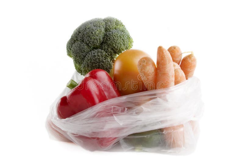 Healthy vegetables in a clear plastic grocery bag on a white background. Healthy vegetables in a clear plastic grocery bag on a white background