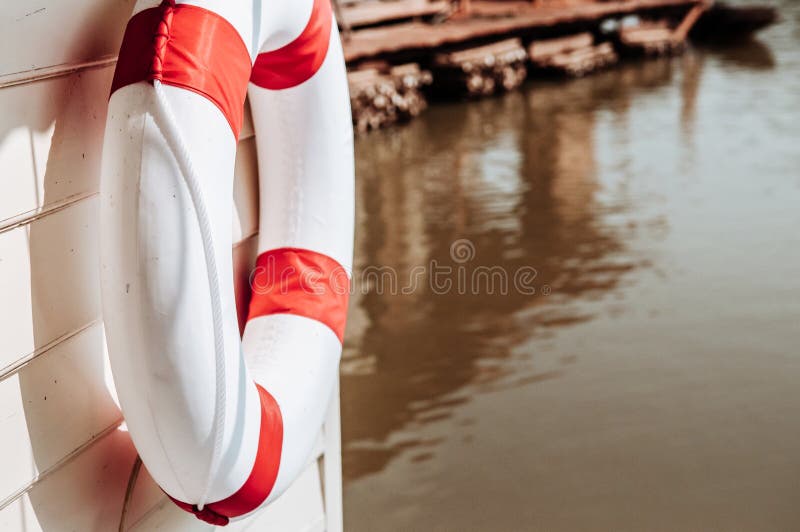 Tore rouge et blanc de balise de vie accrochant sur le mur en bois de la rivière la Floride images stock Tore rouge et blanc de balise de vie accrochant sur le mur en bois de la rivière la Floride images stock
