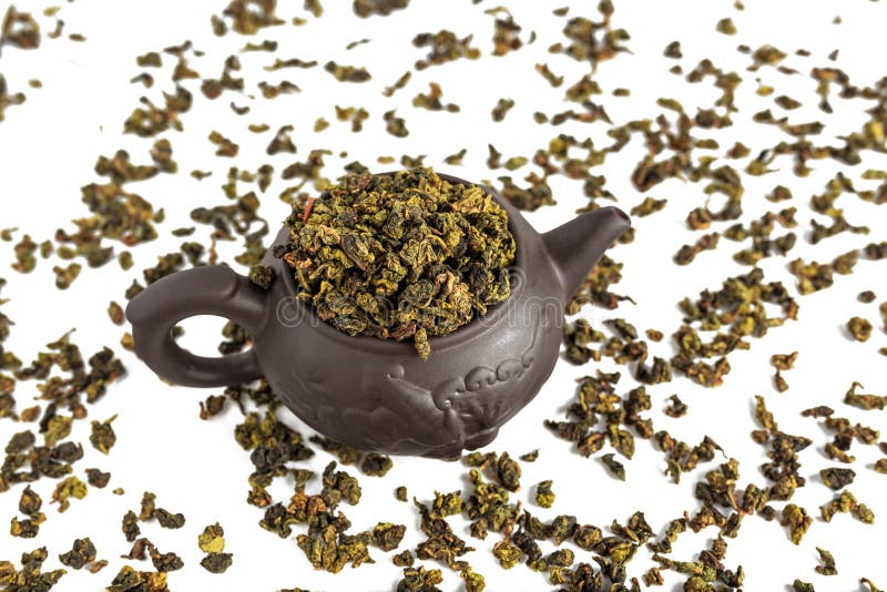 Torka sidor av tetieguanyin, spridda runt om en porslintekanna, ett teblad fotografering för bildbyråer Torka sidor av tetieguanyin, spridda runt om en porslintekanna, ett teblad fotografering för bildbyråer