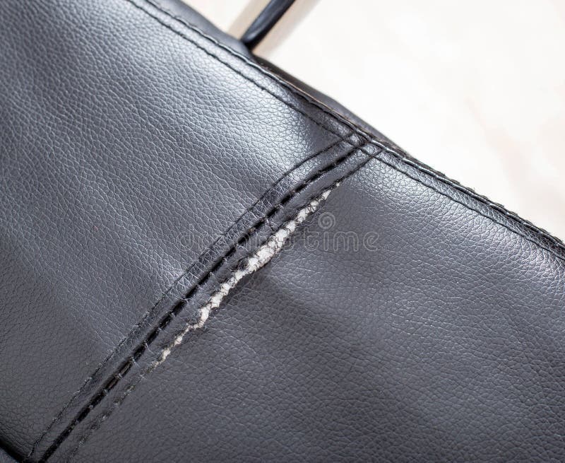 Torn and Battered Leather Back of the Sofa. Poor Quality Leather