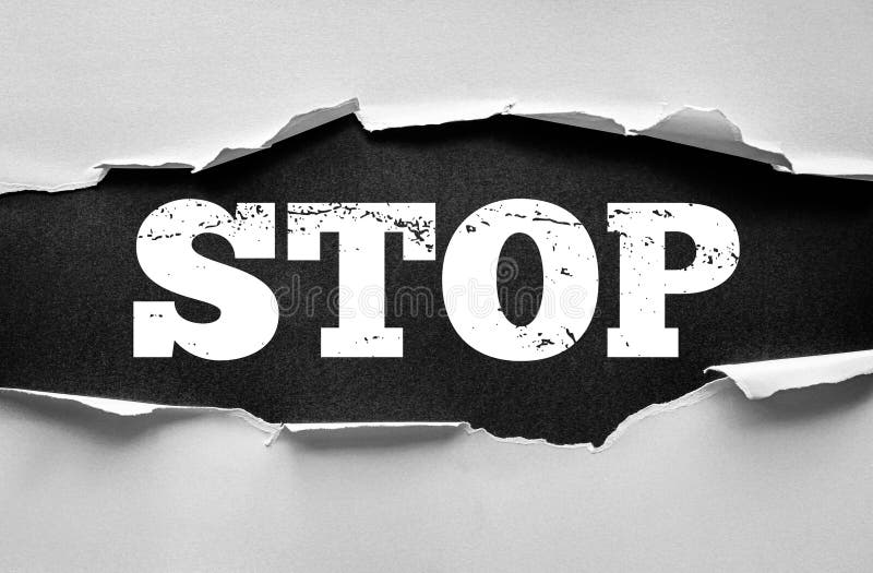 Torn paper revealing bold distressed word STOP on contrasting background. Concept of warning, prohibition, restriction, caution royalty free stock photos