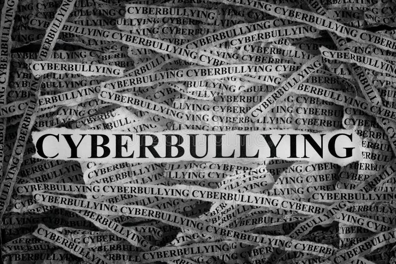 Torn pieces of paper with word Cyberbullying