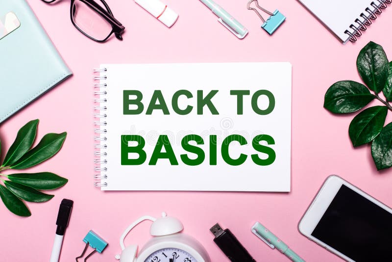 BACK TO BASICS written on a pink background surrounded by stationery and plant leaves. Business concept. BACK TO BASICS written on a pink background surrounded by stationery and plant leaves. Business concept.