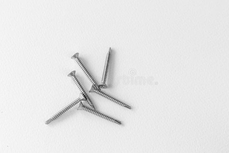 Tornillos metálicos en fondo blanco. Tornillos metálicos en concepto industrial de fondo blanco.