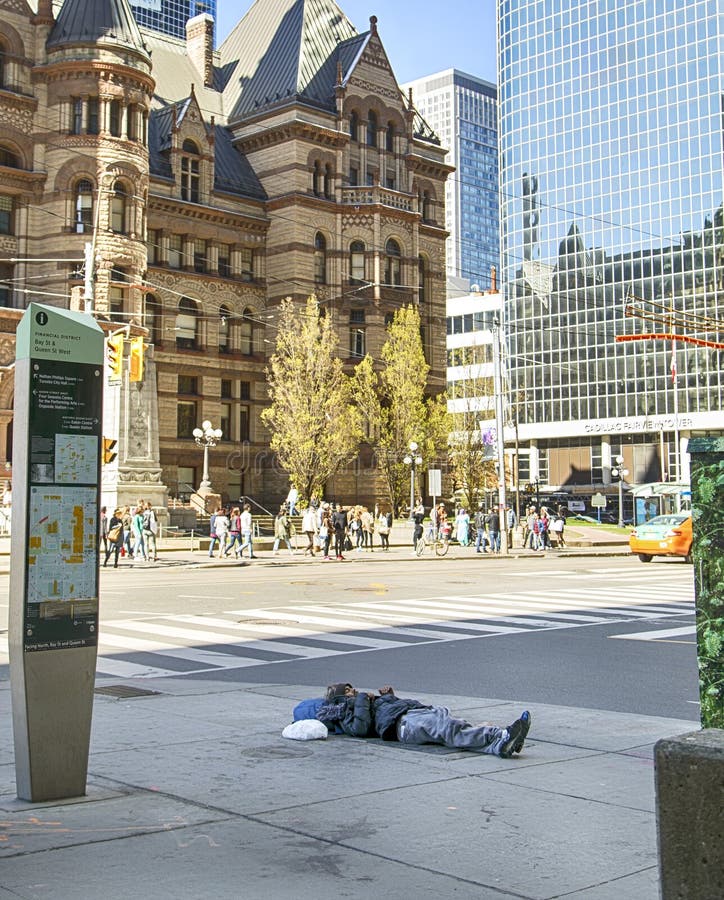 TORONTO, CANADÁ - 13 de mayo de 2016: El hombre sin hogar duerme en la calle en Toronto céntrico, Canadá imagen de archivo libre de regalías TORONTO, CANADÁ - 13 de mayo de 2016: El hombre sin hogar duerme en la calle en Toronto céntrico, Canadá imagen de archivo libre de regalías