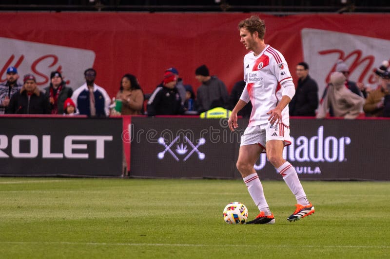 Toronto, ON, Canada - April 20, 2024: Henry Kessler #4 defender of the New England Revolution moves with the ball during the MLS Regular Season match between Toronto FC (Canada) and New England Revolution (USA) at BMO Field. Toronto, ON, Canada - April 20, 2024: Henry Kessler #4 defender of the New England Revolution moves with the ball during the MLS Regular Season match between Toronto FC (Canada) and New England Revolution (USA) at BMO Field