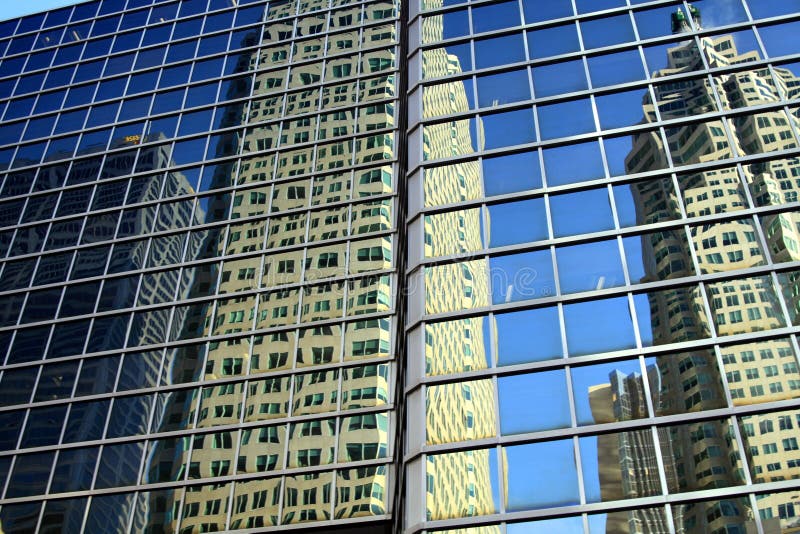 TORONTO KANADA - JANUARI 8 2012: Skyskrapor och molnfri blå himmel som reflekterar i exponeringsglasfasad arkivbild TORONTO KANADA - JANUARI 8 2012: Skyskrapor och molnfri blå himmel som reflekterar i exponeringsglasfasad arkivbild