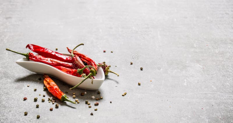 Torr chilipeppar i kopp På stenbakgrund royaltyfria foton Torr chilipeppar i kopp På stenbakgrund royaltyfria foton