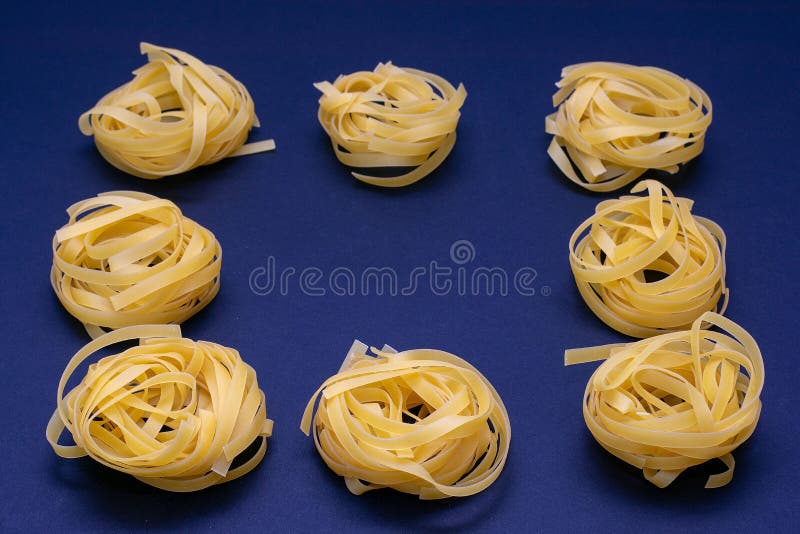 Torr pasta som ?r gul p? en m?rk bakgrund italienska matlagningmatingredienser arkivbild Torr pasta som ?r gul p? en m?rk bakgrund italienska matlagningmatingredienser arkivbild