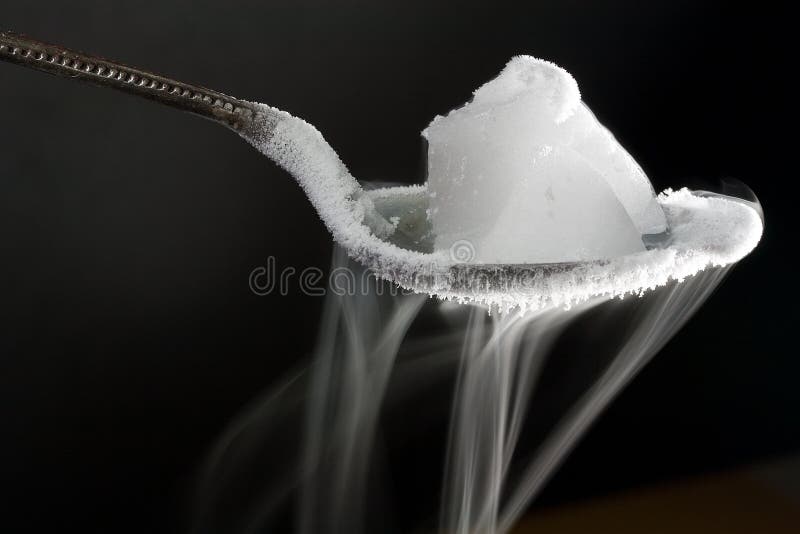 Chunk of dry ice (frozen carbon dioxide) on metal spoon. Also shows water ice crystals forming on the spoon. Chunk of dry ice (frozen carbon dioxide) on metal spoon. Also shows water ice crystals forming on the spoon.