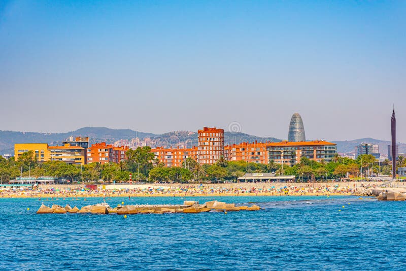 Torre Agbar viewed behind a beach in Barcelona, Spain