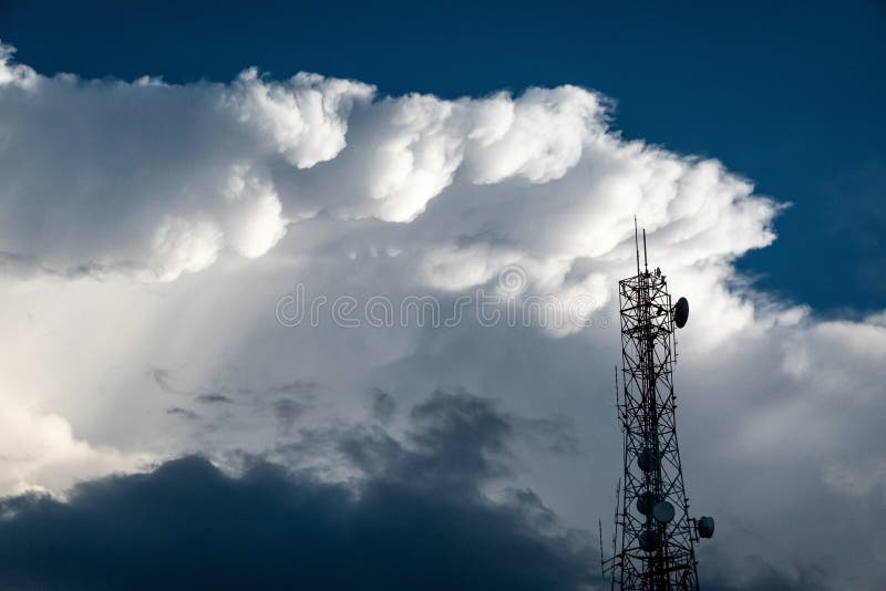 Torre de antena e repetidor de uma comunicação com as nuvens macias brancas no fundo do céu azul foto de stock royalty free Torre de antena e repetidor de uma comunicação com as nuvens macias brancas no fundo do céu azul foto de stock royalty free