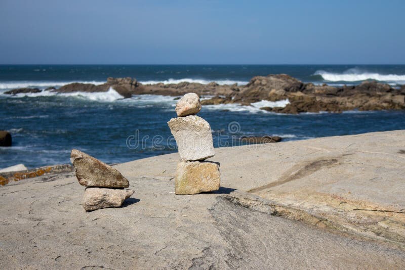 Torre de pequeñas piedras en costa del océano con las rocas en fondo Paisaje marino con el arte de piedra Concepto de la balanza foto de archivo libre de regalías Torre de pequeñas piedras en costa del océano con las rocas en fondo Paisaje marino con el arte de piedra Concepto de la balanza foto de archivo libre de regalías