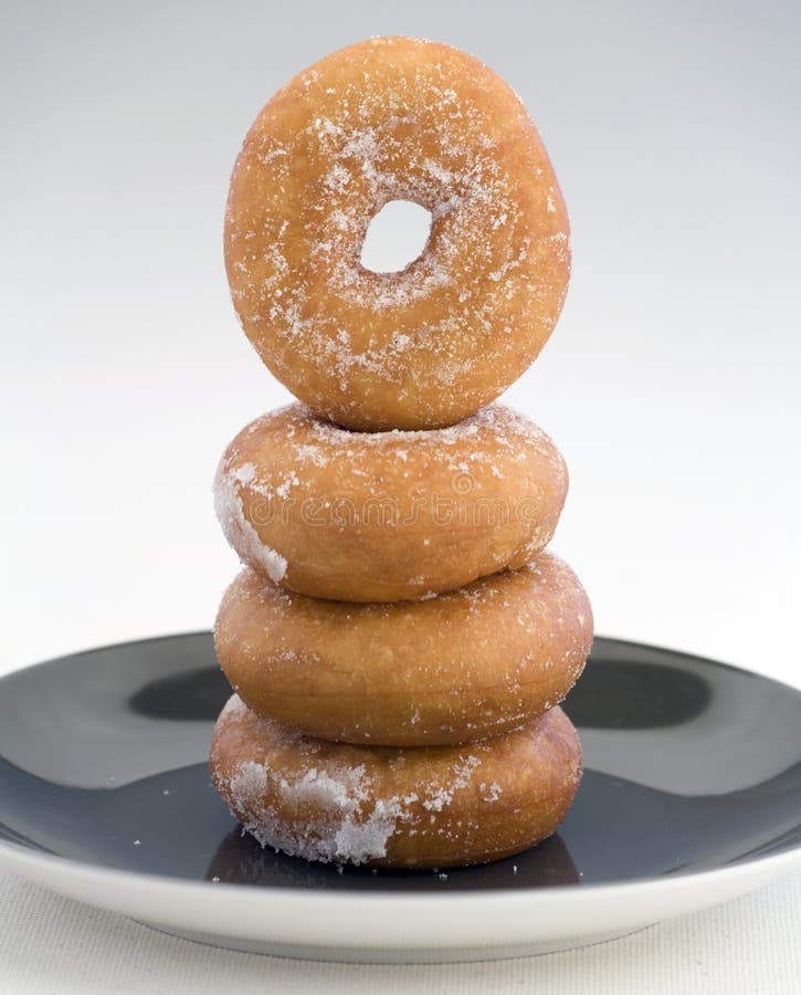 A tower of Donuts on a plate on a Linen background. A tower of Donuts on a plate on a Linen background.