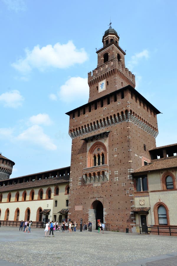 Milan/Italy - June 1, 2015: Ancient central medieval tower of Sforza castle entrance with internal garden and people walking. Milan/Italy - June 1, 2015: Ancient central medieval tower of Sforza castle entrance with internal garden and people walking.