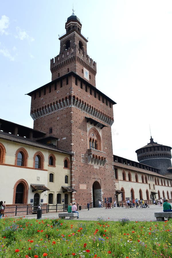 Milan/Italy - June 1, 2015: Ancient central medieval tower of Sforza castle entrance with internal garden and flowering meadow. Milan/Italy - June 1, 2015: Ancient central medieval tower of Sforza castle entrance with internal garden and flowering meadow.