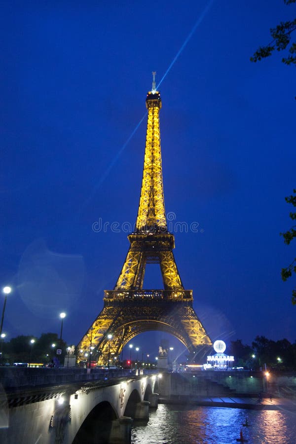 Eiffel Tower illuminated at night with bridge over the Seine River stock photo