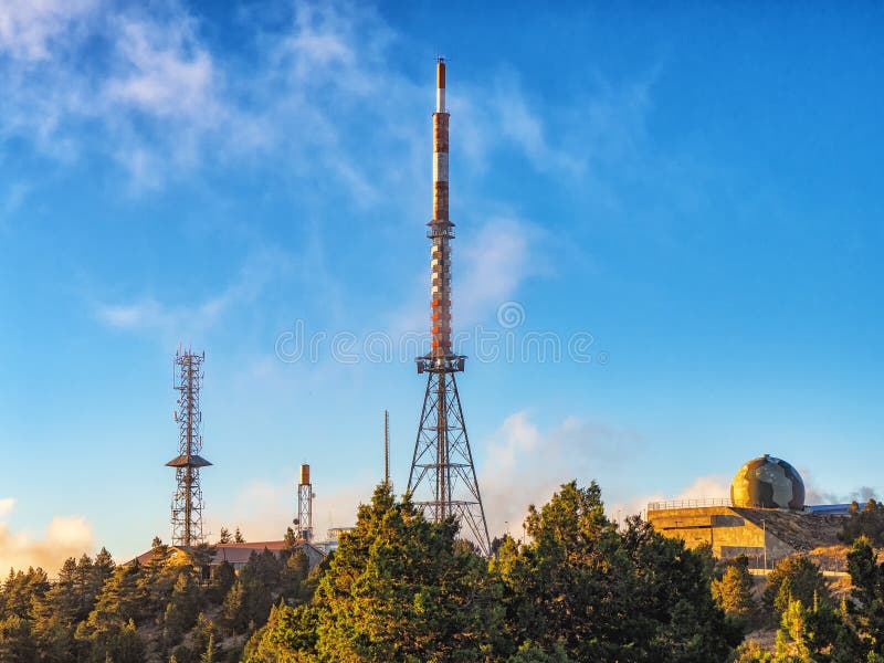Torri di telecomunicazione con le antenne della TV e riflettore parabolico nel tramonto immagini stock Torri di telecomunicazione con le antenne della TV e riflettore parabolico nel tramonto immagini stock