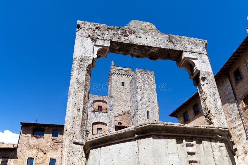 Torri e medievale bene sul reservoir di della piazza a San Gimignano in Toscana in Italia fotografia stock Torri e medievale bene sul reservoir di della piazza a San Gimignano in Toscana in Italia fotografia stock