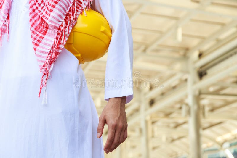 Torso of arab engineer or worker hold in hand yellow helmet stock photos